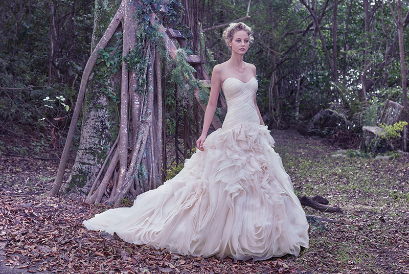 Maggie Sottero Penny: An asymmetrically pleated bodice provides a slim fit through the hips before meeting the grand, swirling tulle and Vincenza organza skirt of this wedding gown. $1,198 at Brides 2 Be By Hope Mitchell. 