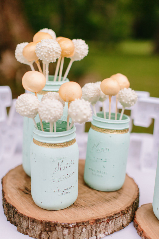 <strong>Wedding Cake Pops</strong>
Wedding cake pops add a playful twist to the traditional wedding cake. Plus, they come in a variety of flavors and can be decorated in many ways. This ranch themed wedding used mason jars to hold the cake pops and each of the flower bouquets at every table.  
