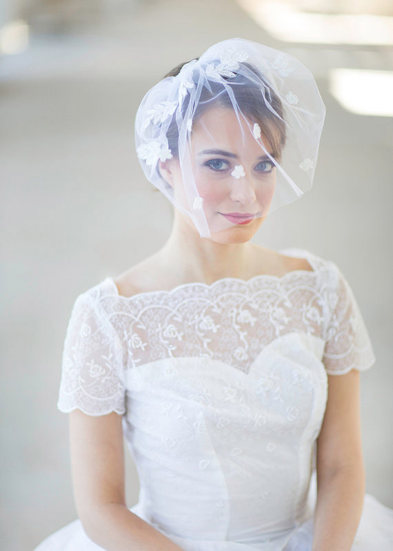 Classic and modern brides alike are embracing the blusher, which kisses the cheeks, like the name suggests. They frame the face in soft tulle and are attached to the crown of the head with a comb, perfect for pairing with an up-do, like this one from JoyandFelicity.