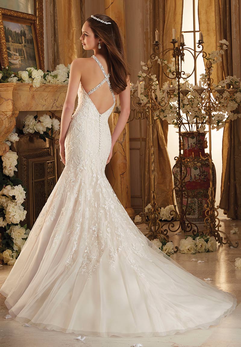 (Mori Lee Bridal Style 8115) Fit-and-flare wedding dress features frosted Alencon lace appliques on net with an eye-catching wide scalloped hem
line. Covered buttons accent the illusion back. 
$1,299, The Dress
Matters, Media, Pa, www.thedressmatters.com.