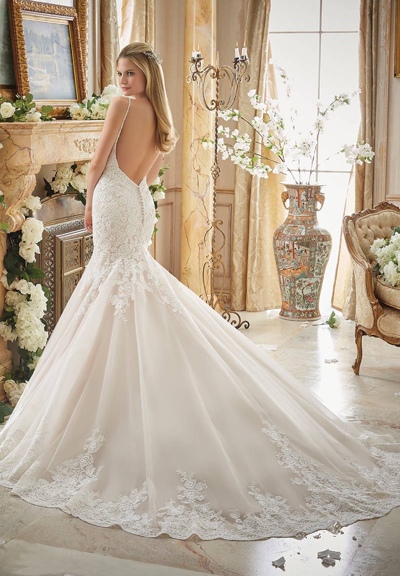 (Mori Lee Bridal Style 2871) Alencon lace appliques embellish the sleeveless dropped waist bodice of this fit-and-flare, tulle gown with chapel train. Beaded spaghetti straps lead into the scalloped V-back with covered button closures. 
$1,249, The
Dress Matters, Media, Pa., www.thedressmatters.com.